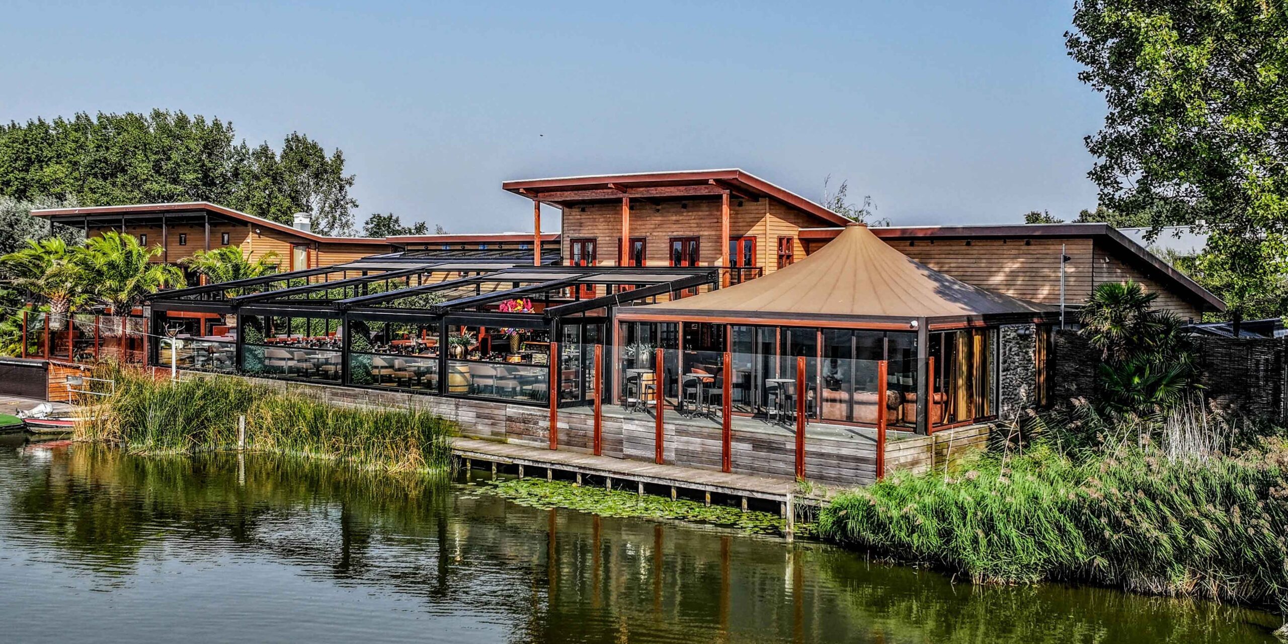 Maatwerk serre en horeca terrasoverkapping aan het water bij Wollebrand Lakehouse