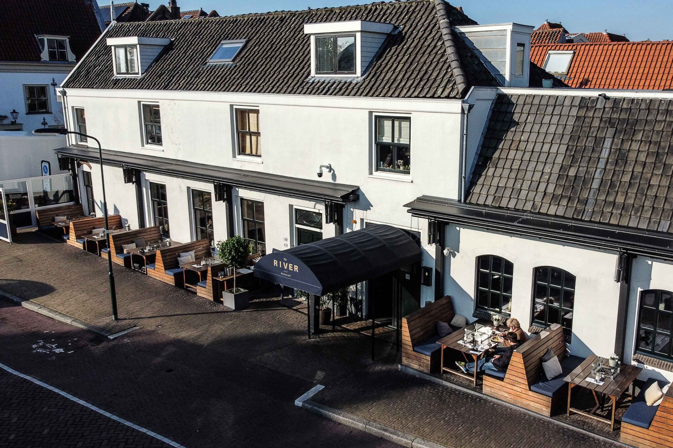 Terrasoverkapping horeca schaararmscherm gesloten The River Voorburg regenbescherming