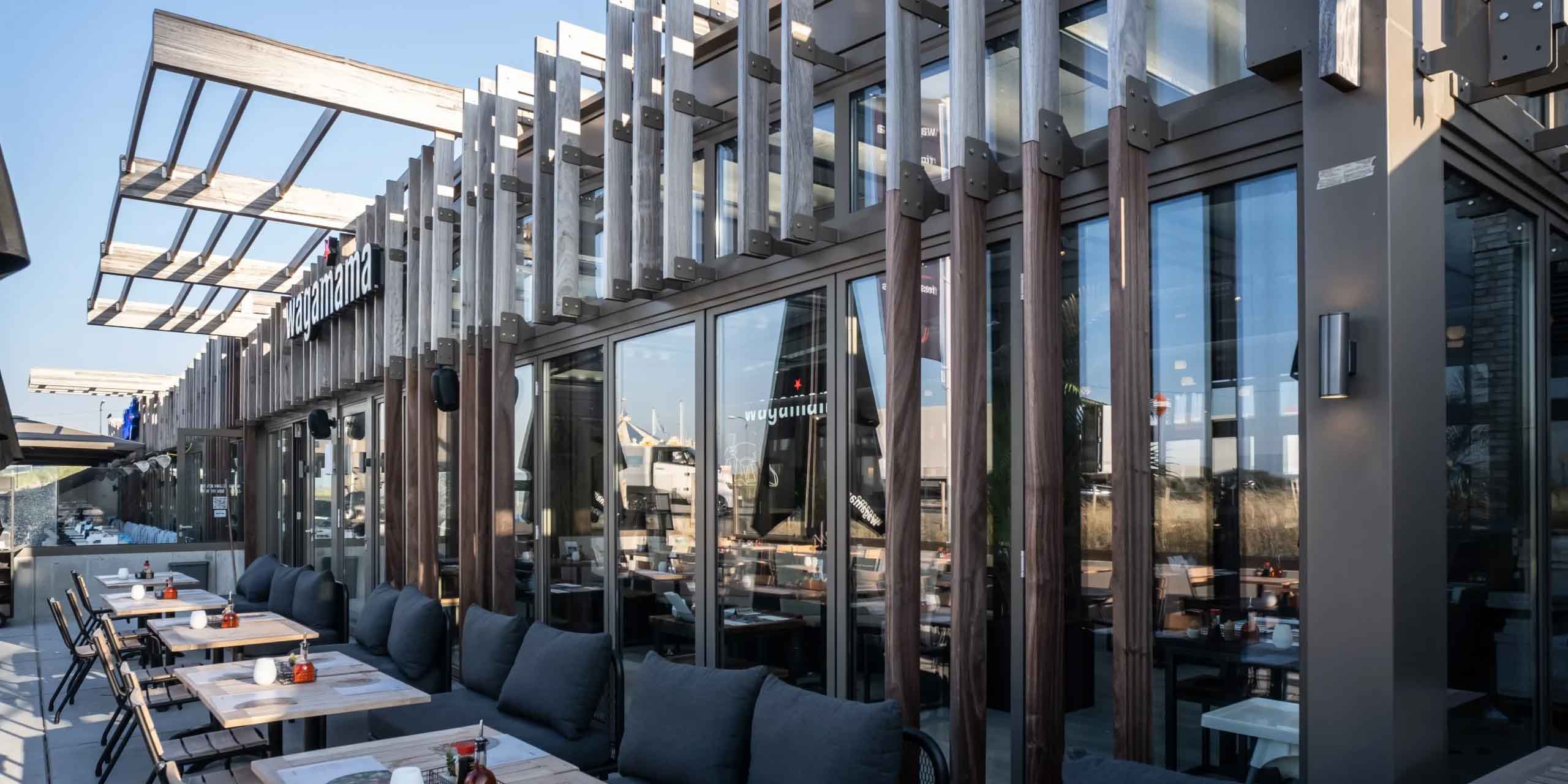 Thermisch verzinkte staalconstructie bekleed met hout voor horeca terrasoverkapping aan zee