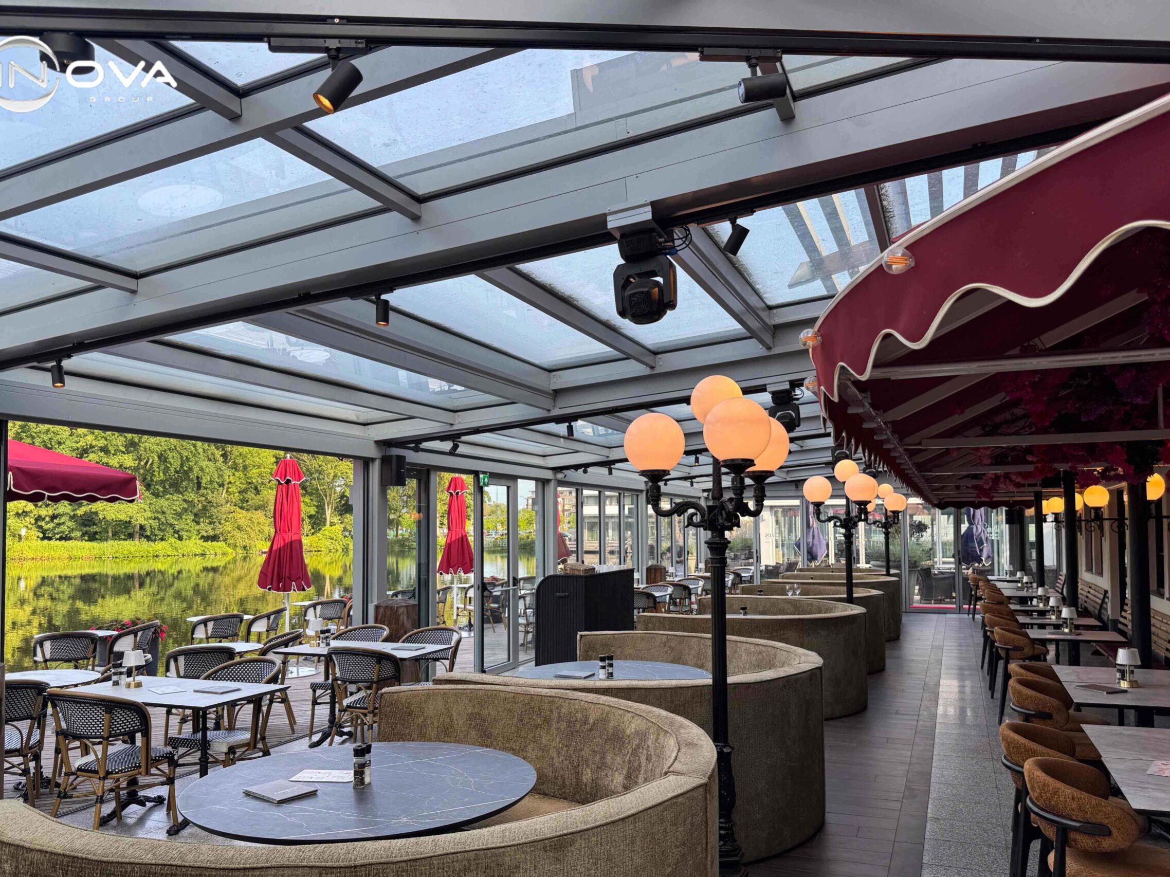 Serre met zitbanken en uitzicht op het water bij restaurant
