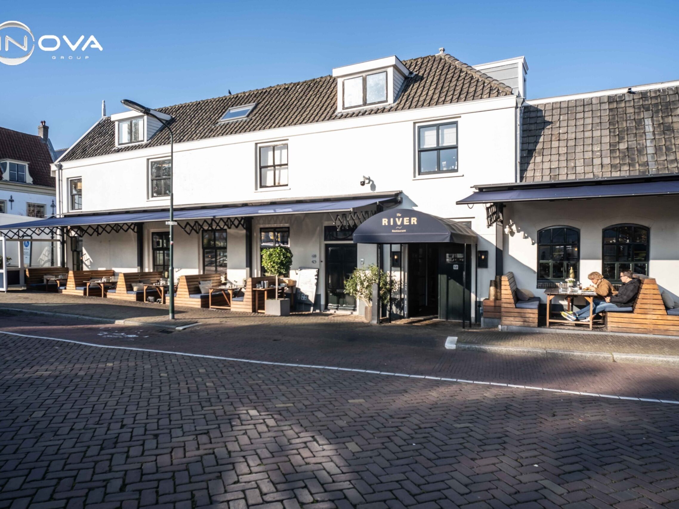 Terrasoverkapping horeca schaararmschermen The River Voorburg monumentaal pand gevelbeeld
