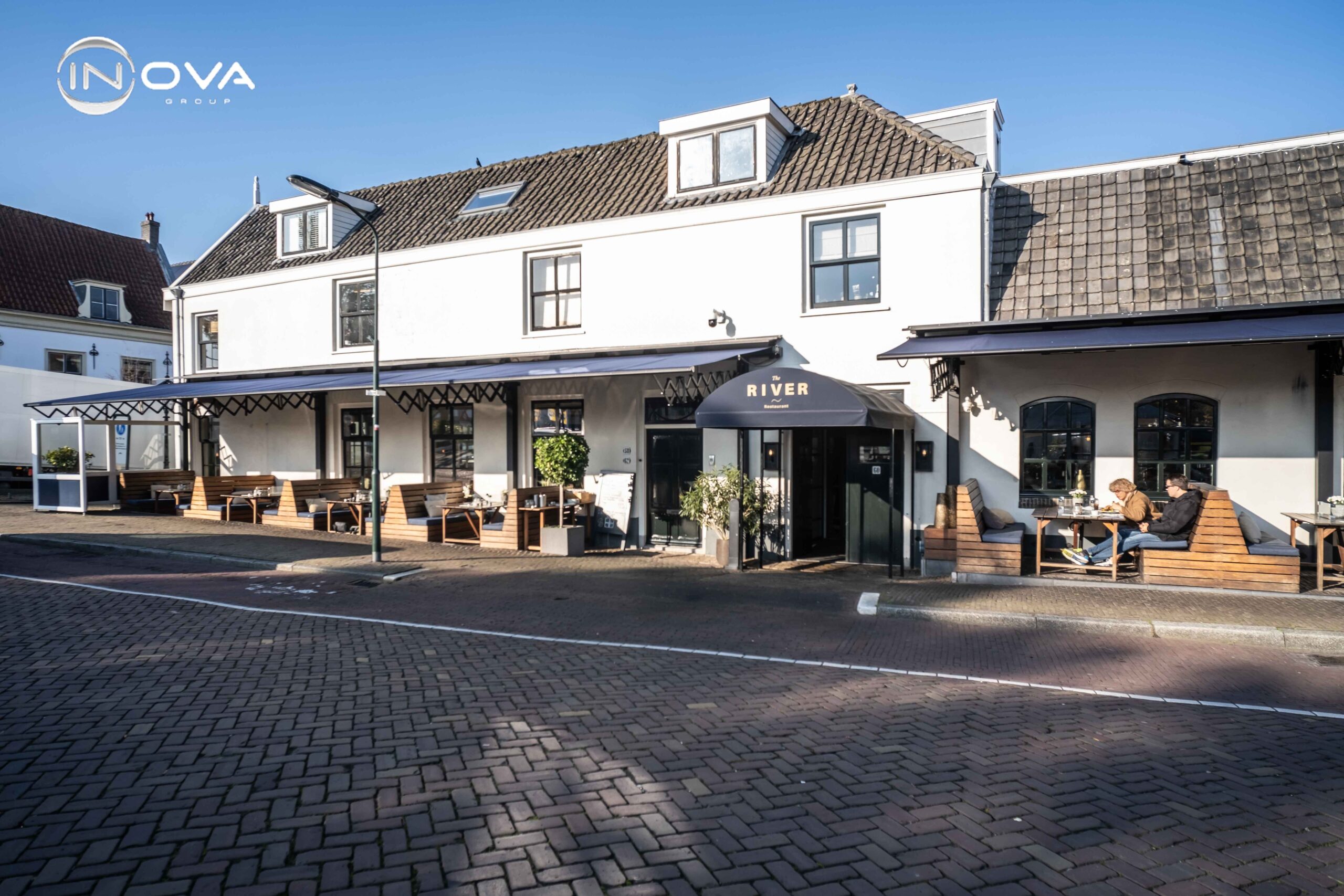 Terrasoverkapping horeca schaararmschermen The River Voorburg monumentaal pand gevelbeeld